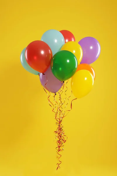 Gäng ljusa ballonger på färg bakgrund. Firande tid — Stockfoto