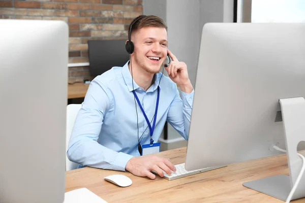 Operador de soporte técnico que trabaja con auriculares y computadora en la mesa en la oficina —  Fotos de Stock