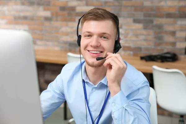 Technical support operator with headset working in office