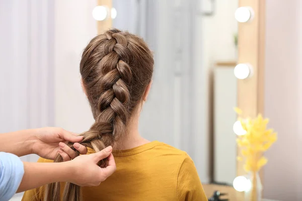 Profissional coiffeuse trançar o cabelo do cliente no salão — Fotografia de Stock