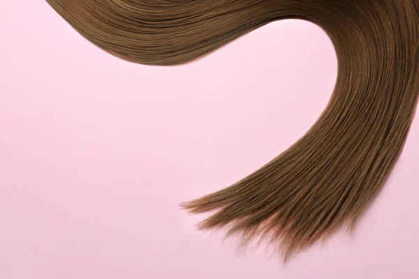 Beaux cheveux raides bruns sur fond de couleur, vue de dessus. Espace pour le texte — Photo