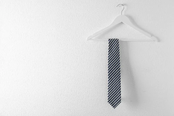 Cravatta su appendiabiti in legno su sfondo bianco. Spazio per testo — Foto Stock