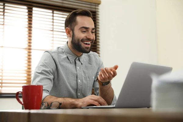 Człowiek za pomocą czatu wideo na laptopie w biurze domowym — Zdjęcie stockowe
