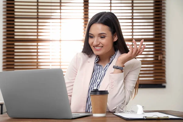 Mujer joven usando chat de vídeo en el ordenador portátil en la oficina en casa — Foto de Stock