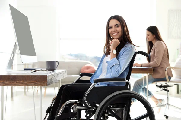 Junge Frau im Rollstuhl nutzt Computer am Arbeitsplatz — Stockfoto