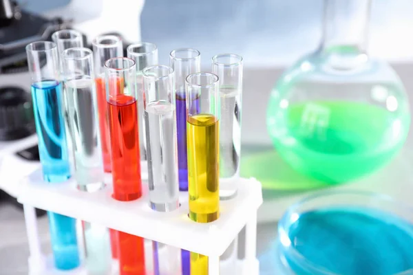 Тестовые трубы с образцами в стойке на столе в химической лаборатории, крупный план — стоковое фото