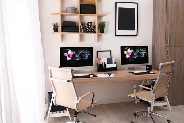 Moderno lugar de trabajo con escritorio grande y computadoras en la habitación. Interior con estilo —  Fotos de Stock