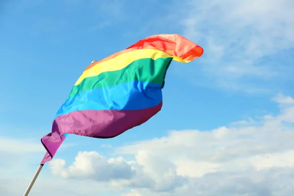 Bright rainbow gay flag revoloteando contra el cielo azul, espacio para el texto. Comunidad LGBT — Foto de Stock