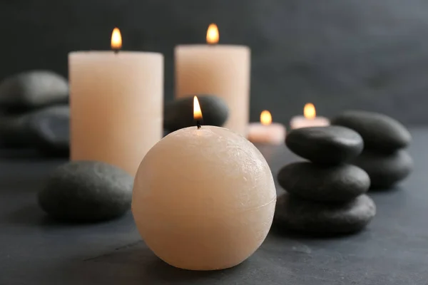 Schöne Komposition mit Kerzen und Wellness-Steinen auf dem Tisch — Stockfoto