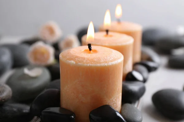 Krásná skladba se svíčkami a wellness kameny na stole — Stock fotografie