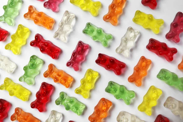 Many delicious little jelly bears on white background, top view — Stock Photo, Image