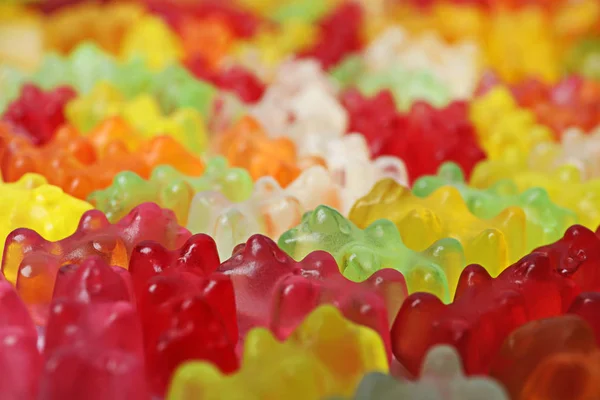 Muitos deliciosos ursos de geleia coloridos como fundo, close-up — Fotografia de Stock
