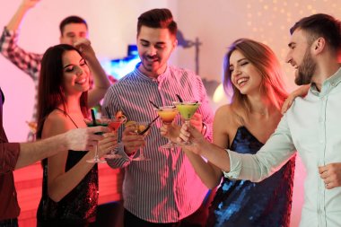 Partide martini kokteyli tutan bir grup genç