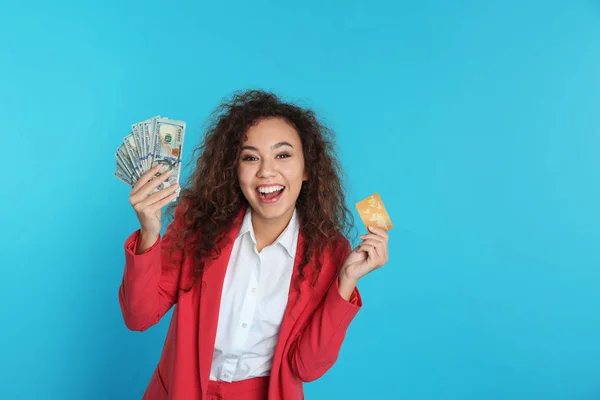 Mujer de negocios afroamericana con dinero y tarjeta de crédito sobre fondo de color. Espacio para texto —  Fotos de Stock