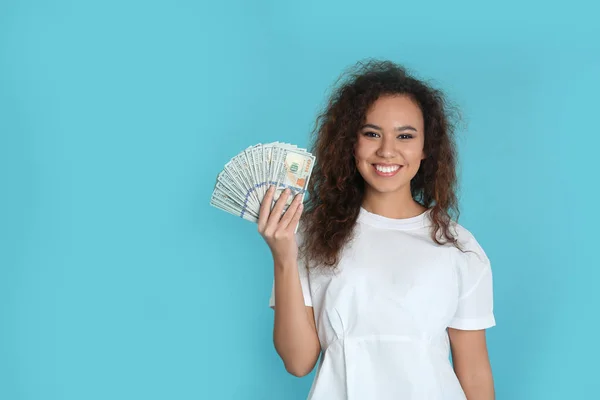 Junge afrikanisch-amerikanische Frau mit Geld auf farbigem Hintergrund. Raum für Text — Stockfoto