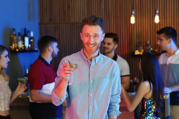 Młody człowiek z kieliszkiem koktajlu martini na imprezie — Zdjęcie stockowe