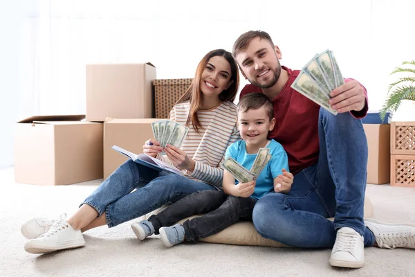 Happy family with money on floor at home