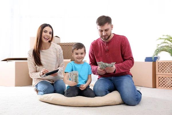 Šťastná rodina s penězi na podlaze doma — Stock fotografie