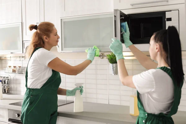 Equipo de conserjes profesionales limpiando la cocina en interiores — Foto de Stock