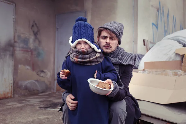 Pobre pai e criança com pão no despejo — Fotografia de Stock