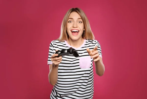 Emozionale giovane donna che gioca ai videogiochi con controller su sfondo a colori — Foto Stock