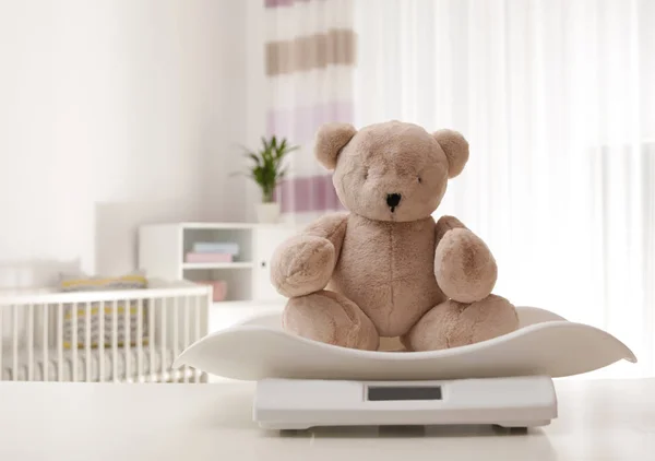 Baby vågar med nallebjörn på bord inomhus, plats för text — Stockfoto