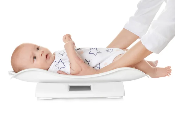 Arzt wägt Baby auf Waage vor weißem Hintergrund — Stockfoto