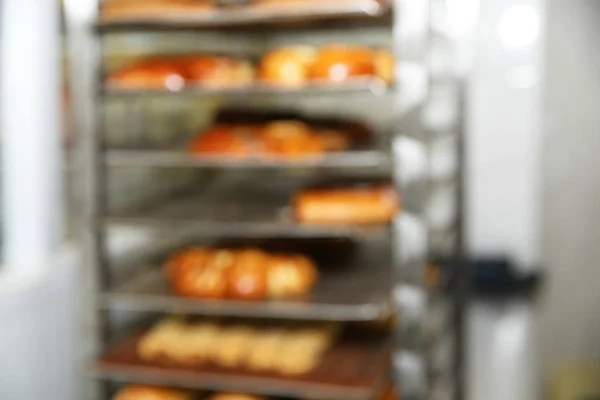 Vista turva do rack com pastelaria na oficina de padaria — Fotografia de Stock