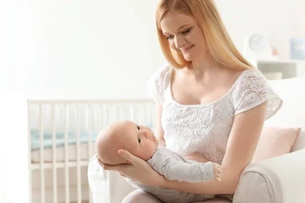 Glückliche Mutter mit ihrem Baby im Sessel zu Hause — Stockfoto