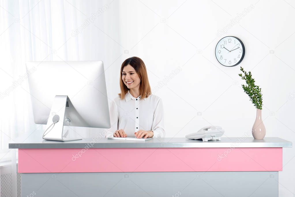 Beautiful woman working at reception desk in beauty salon