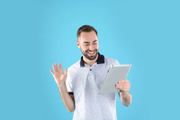 Man menggunakan tablet untuk video chat pada latar belakang warna — Stok Foto