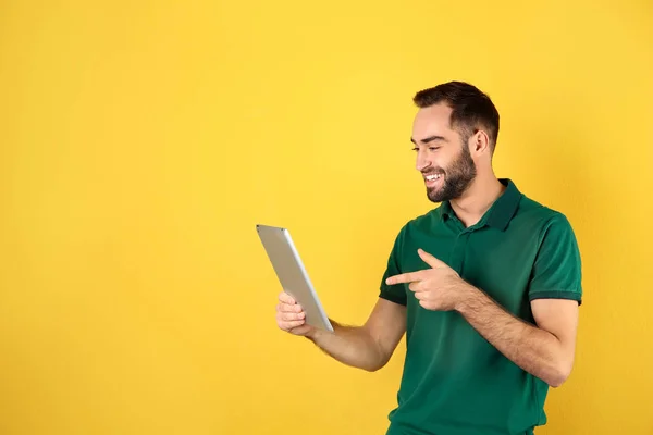 Człowiek za pomocą tabletu do rozmów wideo na kolorowym tle. Miejsce na tekst — Zdjęcie stockowe