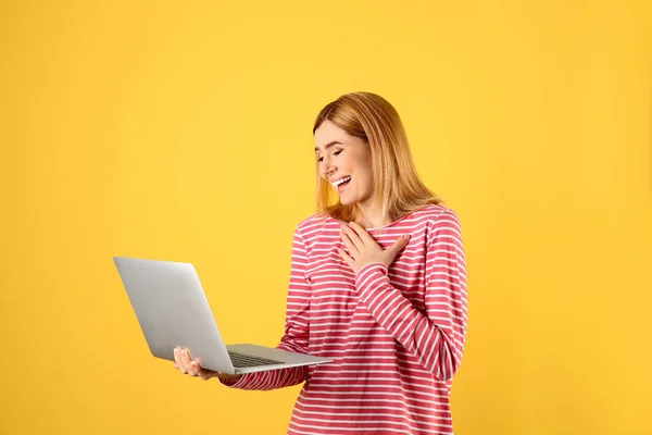 Renk arkaplanındaki görüntülü sohbet için dizüstü bilgisayar kullanan kadın — Stok fotoğraf