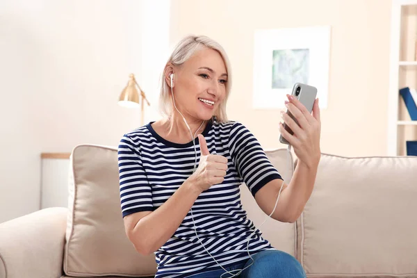 Mulher madura usando bate-papo por vídeo no celular em casa — Fotografia de Stock