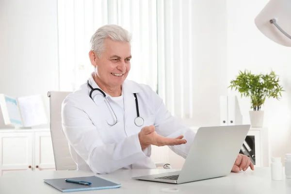 Médico consulta paciente usando vídeo chat no laptop na clínica — Fotografia de Stock