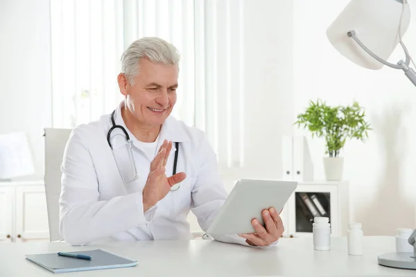 Lekarz konsultingu pacjenta za pomocą czatu wideo na tablecie w klinice — Zdjęcie stockowe