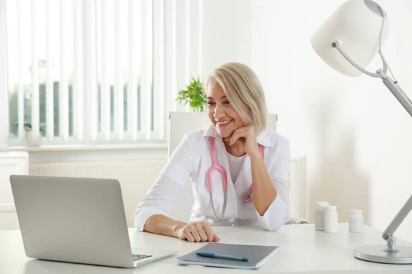Doctor Consulting patient använda videochatt på laptop i kliniken — Stockfoto