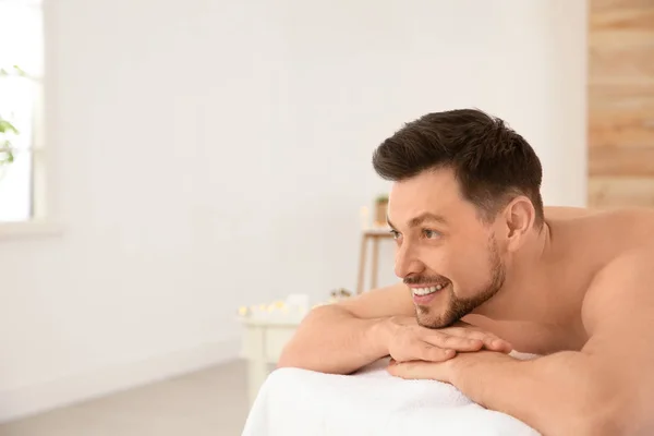 Yakışıklı adam spa salonunda masaj masasında rahatlatıcı, metin için alan — Stok fotoğraf