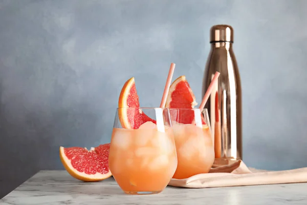 Glas grapefrukt cocktails serveras på bordet mot färg bakgrund. Utrymme för text — Stockfoto