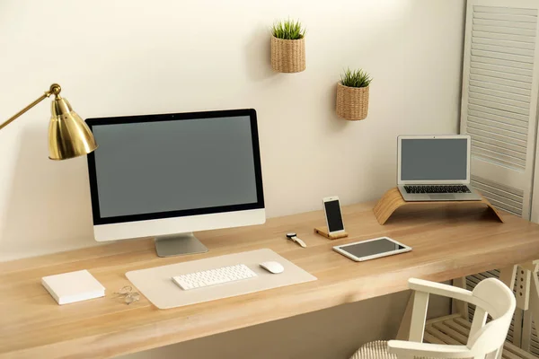 Elegante interior del lugar de trabajo con ordenador moderno en la mesa. Burla para el diseño — Foto de Stock