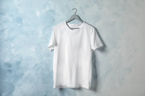 Hanger with white t-shirt on color background. Mockup for design — Stock Photo, Image
