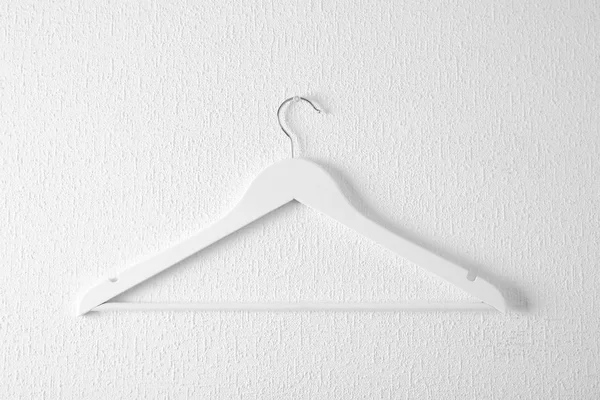 Lege kleerhanger op lichte muur. Kledingkast accessoire — Stockfoto