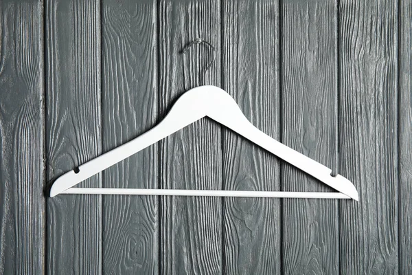 Lege kleding hanger op houten muur. Kledingkast accessoire — Stockfoto