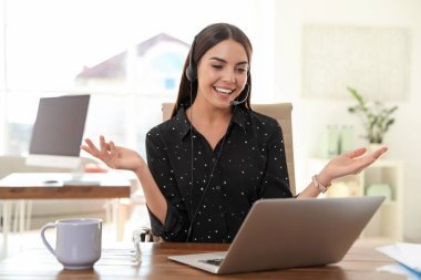 Merkez ofisteki bilgisayarda görüntülü konuşma yapan genç bir kadın.