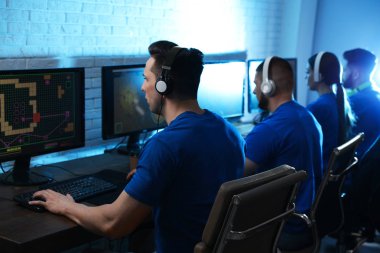 Gençler kapalı bilgisayarlarda video oyunları oynuyorlar. Esports turnuvası