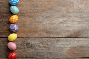 Ahşap masa üzerinde boyalı Paskalya yumurtaları Düz yatıyordu kompozisyon, metin için alan
