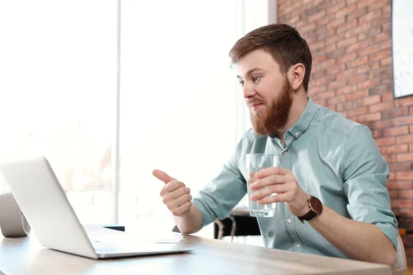 Young man using video chat on laptop in home office — 스톡 사진