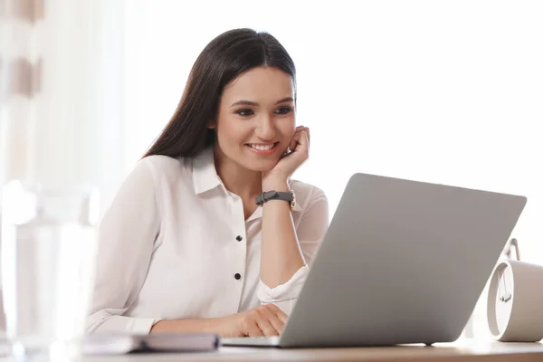 Młoda kobieta korzystająca z czatu wideo na laptopie w biurze — Zdjęcie stockowe