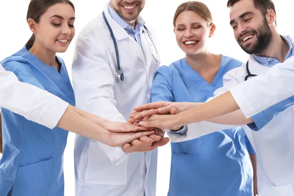 Equipo de médicos poniendo las manos juntas sobre fondo blanco. Concepto de unidad — Foto de Stock