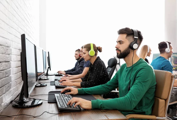 Молоді люди грають у відеоігри на комп'ютерах у приміщенні. Турнір з кіберспорту — стокове фото